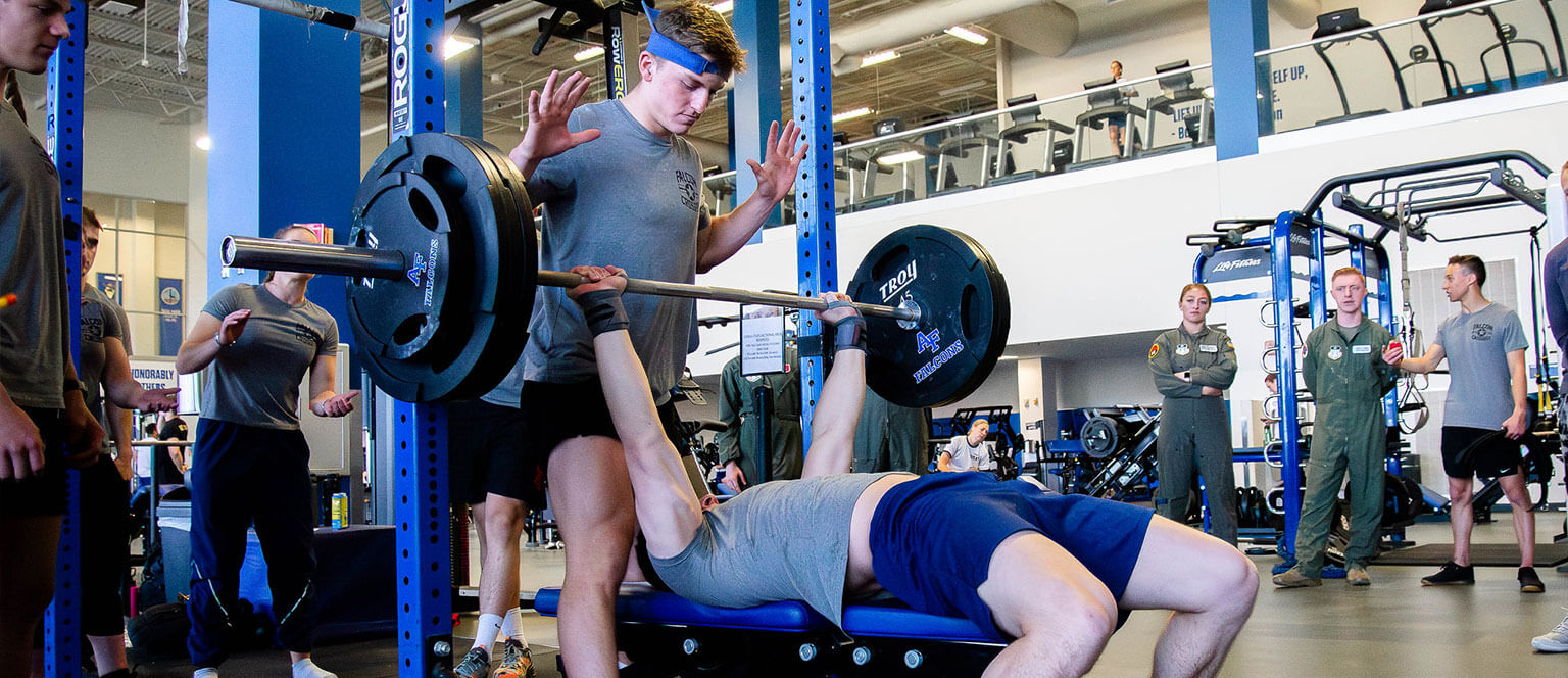 A cadet does a bench press for the Falcon CrossFit Club.