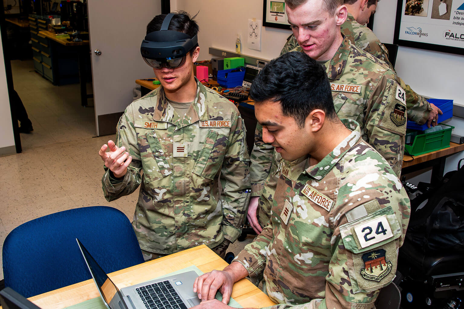 Cadets 1st Class Ameen Khan, front, Lucas Jones, middle, and Sam Smith, left, program changes into the gaze-assisted wheelchair, the U. S. Air Force Academy Department of Electrical and Computer Engineering capstone project.
