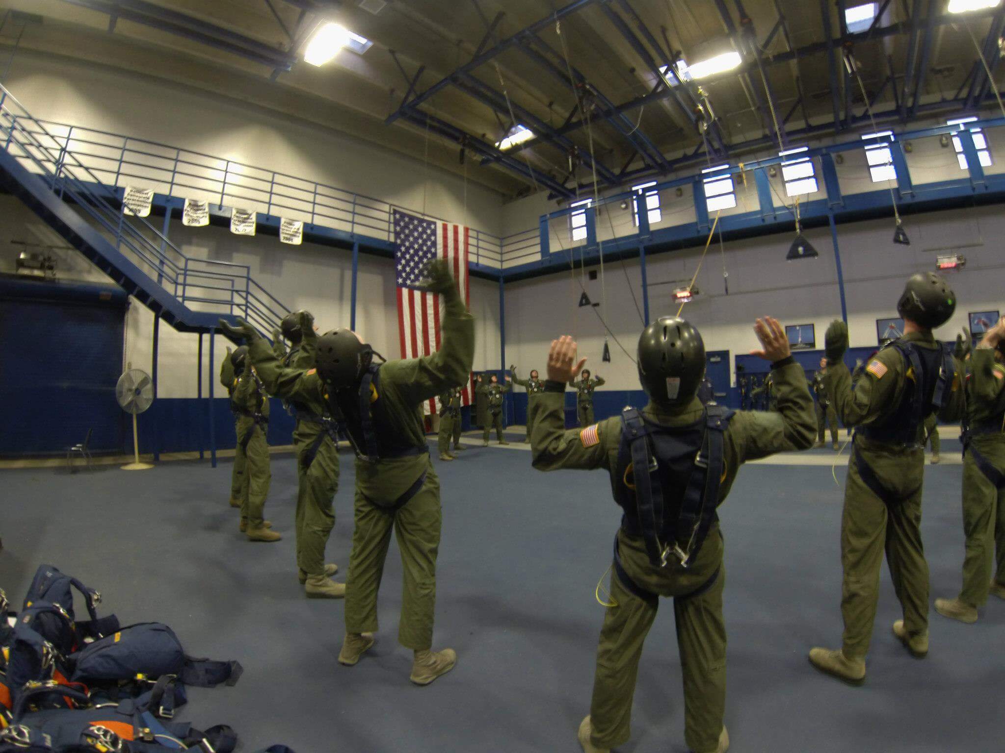 Cadets in hanger wearing flight suits and helmets
