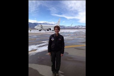 Female military pilot in front of airplane