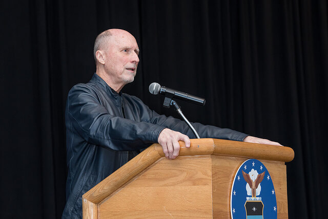 Author Robert Olen Butler stands behind a lectern 