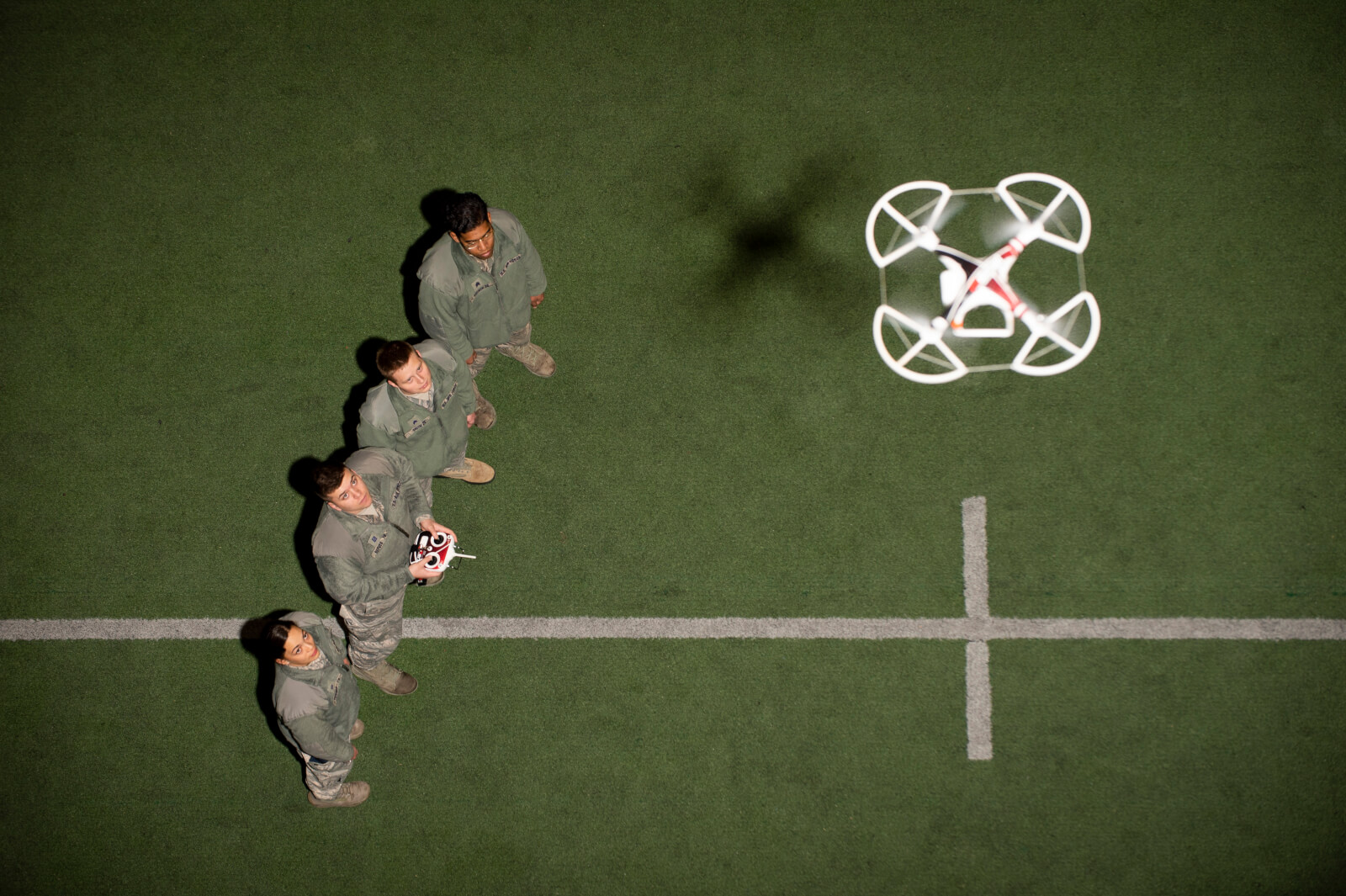 four cadets with drone flying above them, unmanned aerial systems