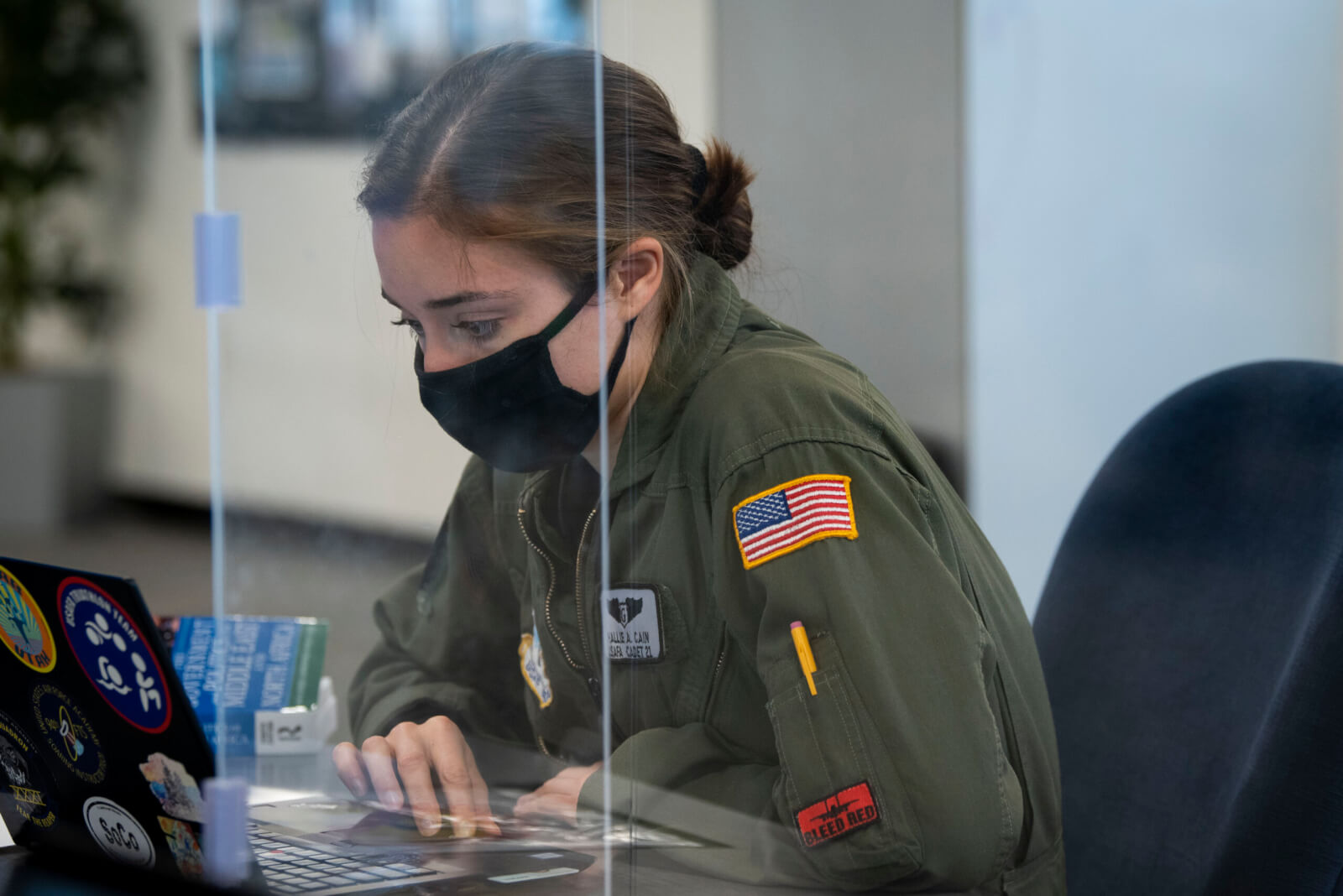 Cadet at laptop computer with Plexiglass shield