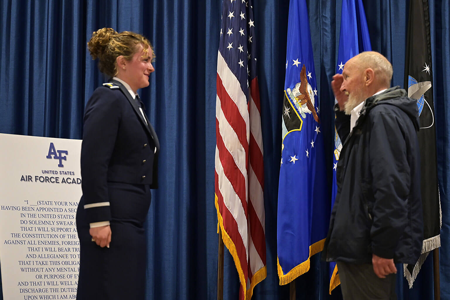 Marine veteran Carl Lewis salutes Cadet 1st Class Billie Botes at the Cadet Squadron 14 commissioning ceremony at Arnold Hall.