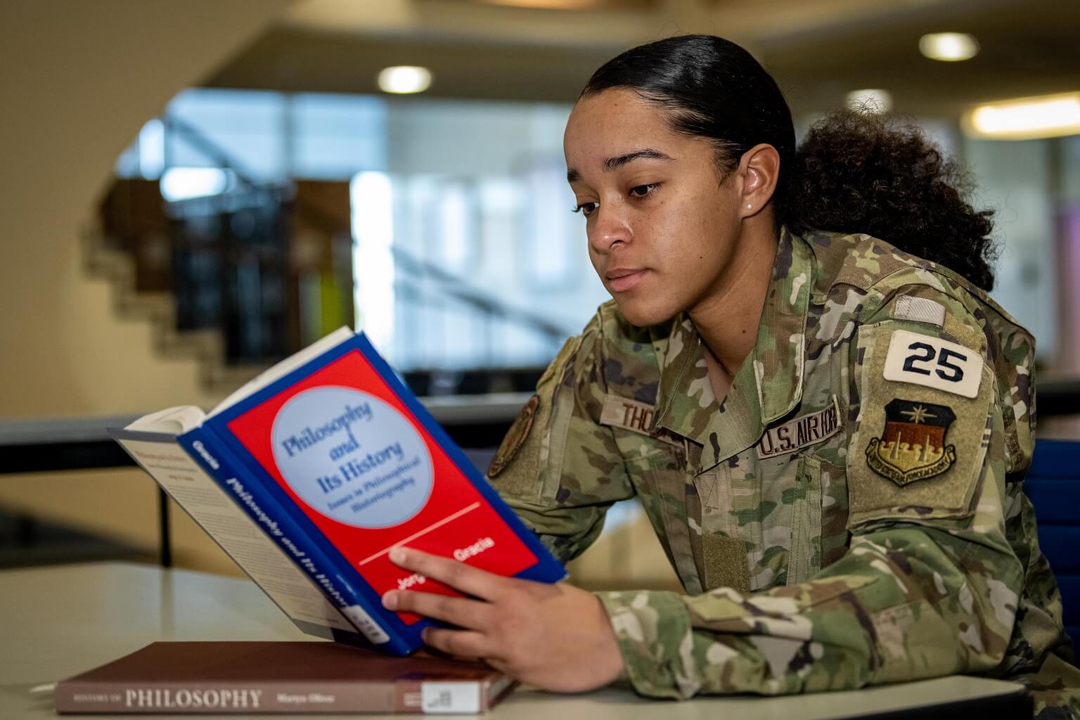 cadet reading philosophy book in library