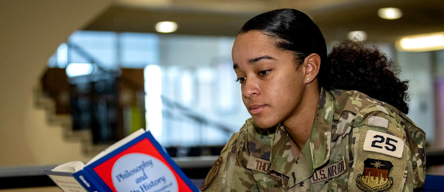 cadet reading philosophy book in library