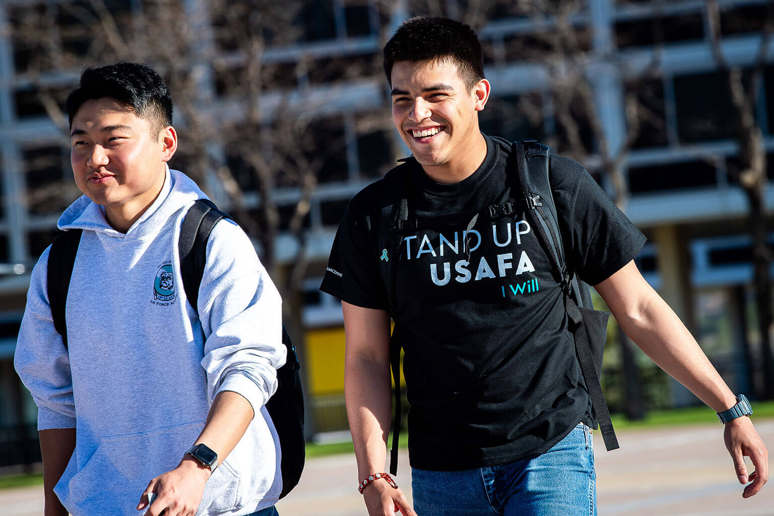 Two cadets sport their denim and U.S. Air Force Academy “Stand Up USAFA” T-shirts walk on the Terrazzo between classes.