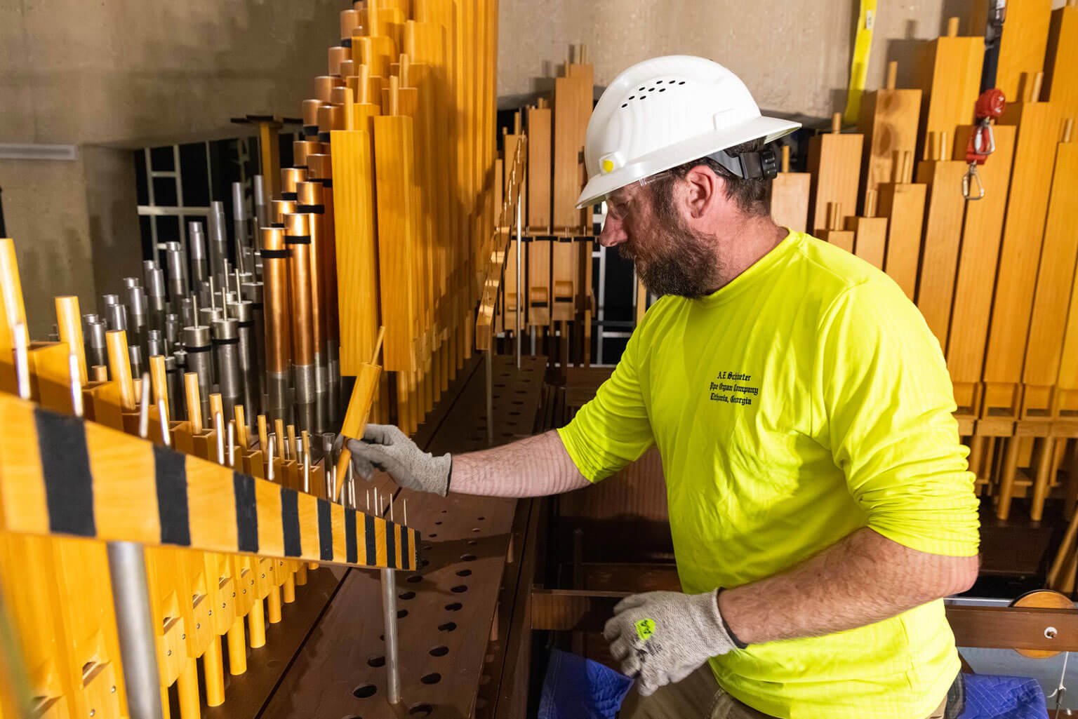 Jeremiah Hodges, an organ restorer with A.E. Schlueter Pipe Organ Company, reinstalls a wooden pipe into the Catholic organ in the Cadet Chapel at the U.S. Air Force Academy, Colo., July 15, 2025. A.E. Schlueter Pipe Organ Company is one of the 75 contractors/trade partners assisting JE Dunn Construction, the primary contractor hired to lead the Cadet Chapel renovation. (U.S. Air Force photo by Trevor Cokley)