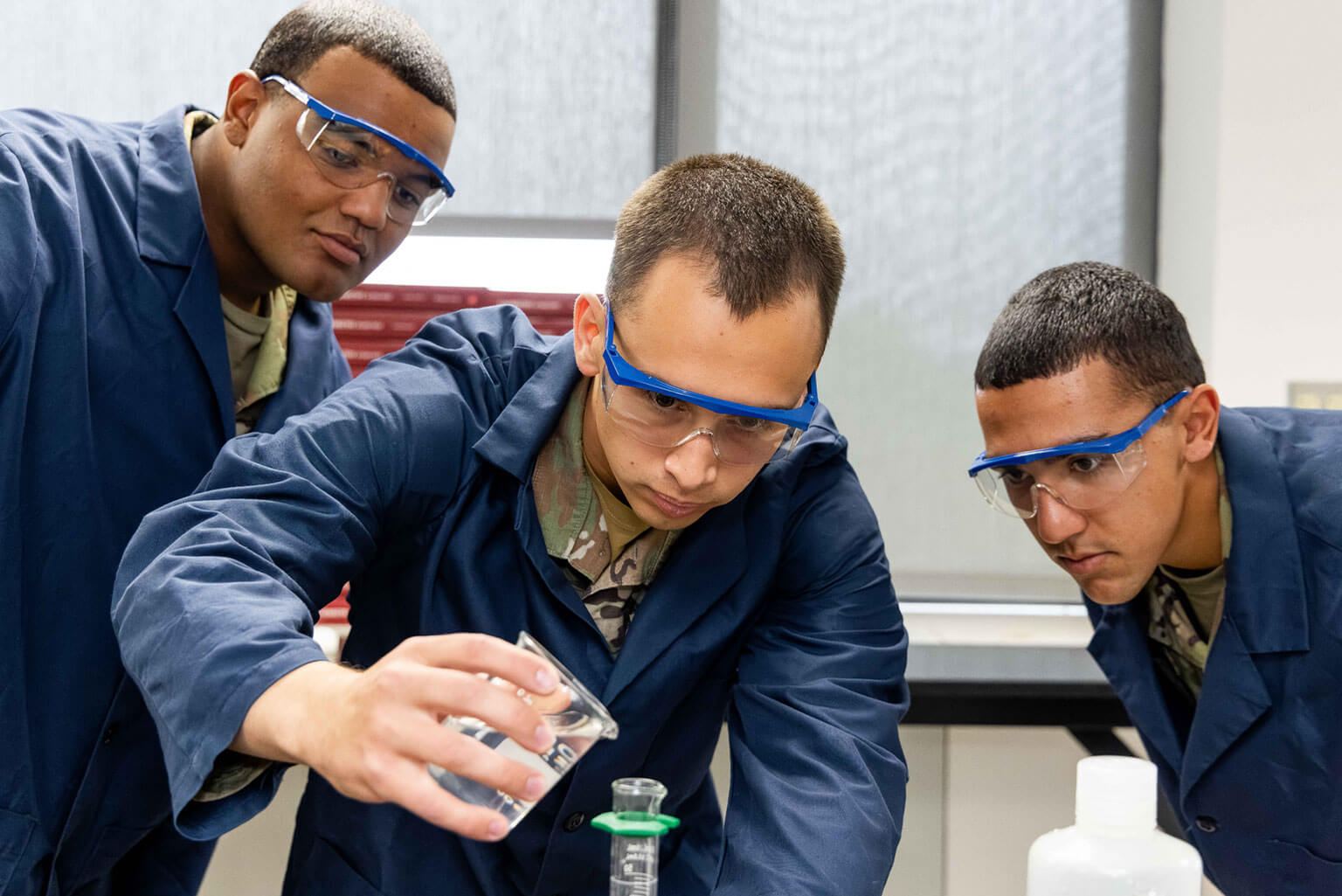 Then-Cadet Candidate Roman Bereguta, center, conducts a chemistry experiment with classmates at the U.S. Air Force Academy Preparatory School, Colo., Aug. 26, 2025. After four years away from school, he finished the year earning dean’s list honors in three of four quarters. (U.S. Air Force photo by Trevor Cokley)