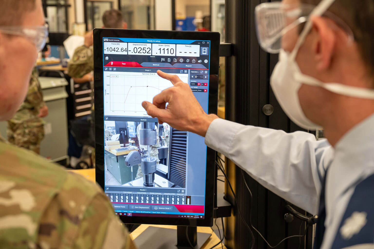 Lt. Col. Matthew Schwaab (right), an assistant professor of mechanical engineering, shows Cadet 4th Class Kydan Echard, a civil engineering major, a force vs. displacement graph during a tensile test at the U.S. Air Force Academy, Colo., March 18, 2026. Cadets use the graph’s stress-strain curve to reveal key material properties during the test. (U.S. Air Force photo by Tech. Sgt. Zach Vaughn)