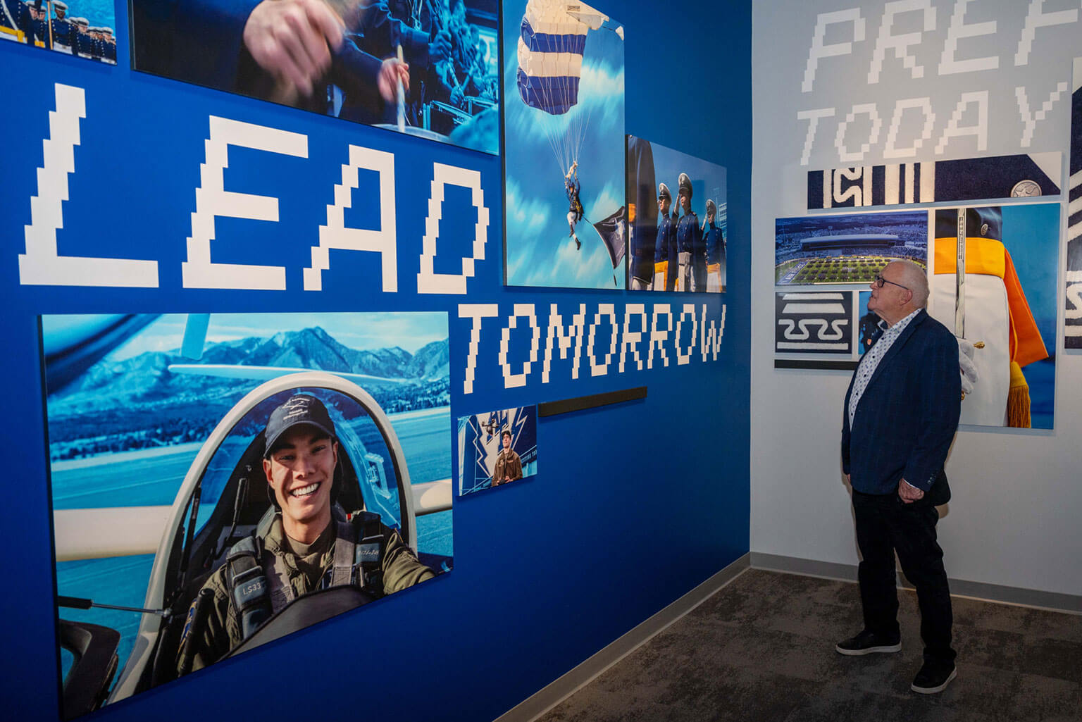 Tim Jackson, Denver resident and first visitor, views cadet imagery in a gallery during the Hosmer Visitor Center grand opening at the U.S. Air Force Academy, Colo., May 16, 2026. Designed to resemble an aircraft taking flight, the Hosmer Visitor Center has six interactive galleries designed to showcase the 47-month cadet journey from civilian to Air Force or Space Force officer. (U.S. Air Force photo by Tech. Sgt. Zach Vaughn)