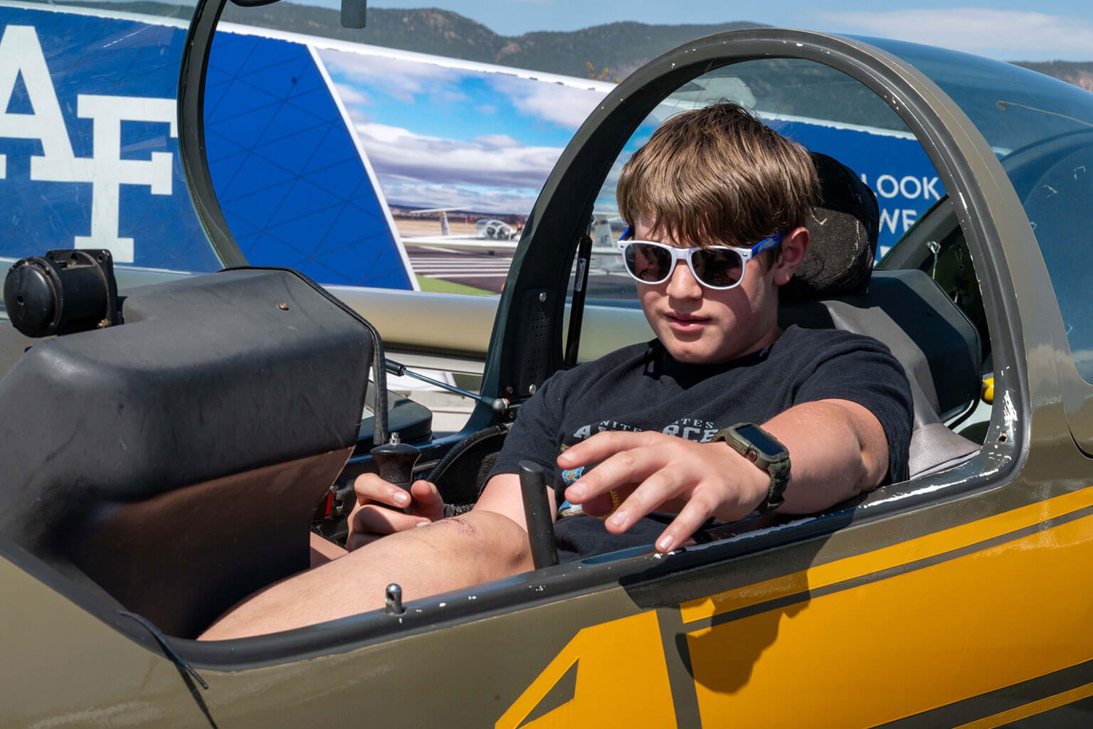 David Goddard, a 13-year-old resident of Colorado Springs, sits in a glider static display during the Hosmer Visitor Center grand opening at the U.S. Air Force Academy, Colo., May 16, 2026. Cadets from the Academy’s glider program answered questions and explained how gliders are used to develop airmanship and flight skills through hands-on training. (U.S. Air Force photo by Tech. Sgt. Zach Vaughn)