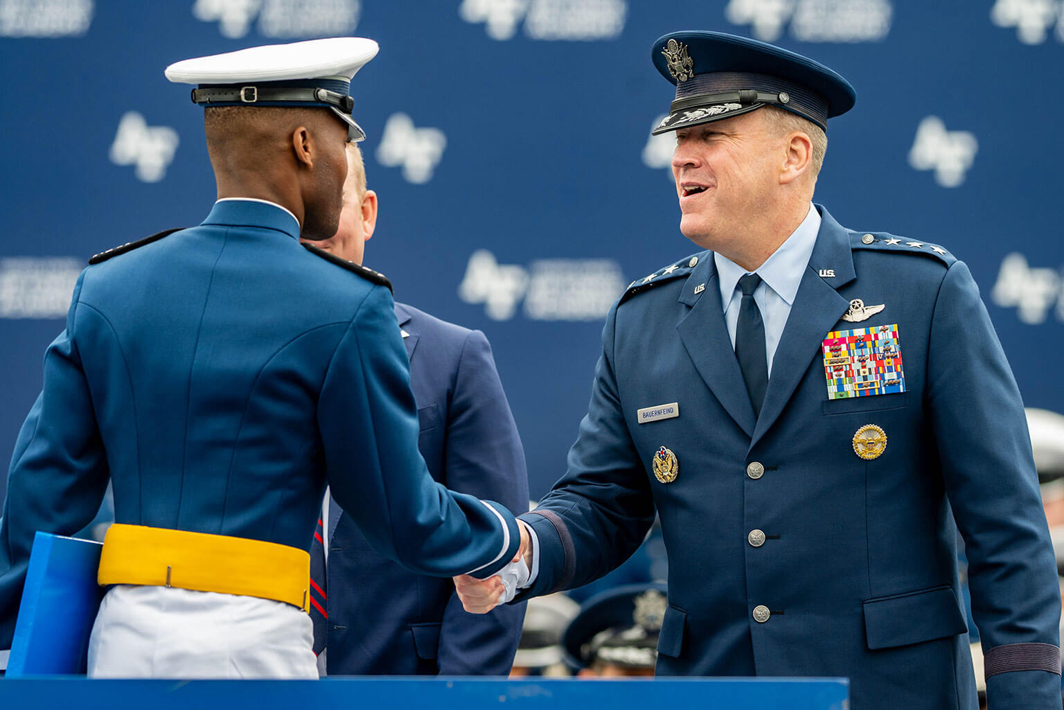 U.S. Air Force Academy Superintendent Lt. Gen. Tony Bauernfeind shakes hands with a newly commissioned officer during the U.S. Air Force Academy’s 2026 graduation ceremony held at Falcon Stadium on the Academy, Colo., May 28, 2026. Wilsbach celebrated the culmination of the cadets' 47-month journey, emphasizing the resilient warrior ethos required of these new leaders to outpace adversaries and deliver unmatched global airpower. (U.S. Air Force photo by Jonathan Suni)