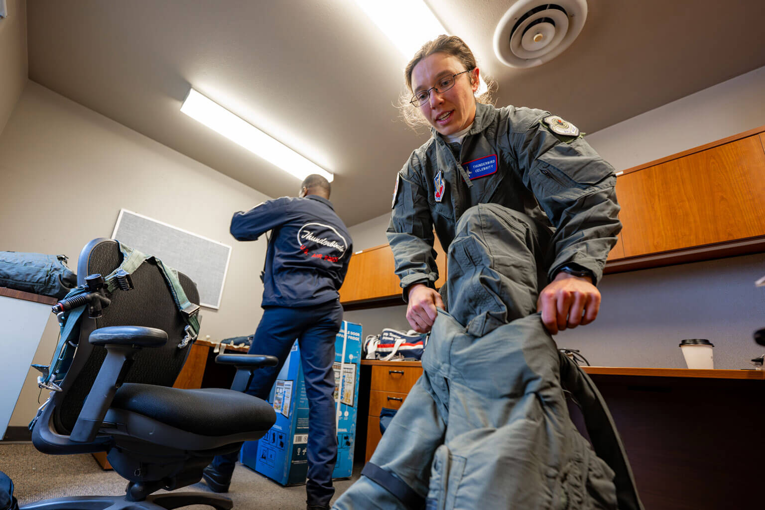 Taylor Lorbiecki, a U.S. Air Force Academy Advanced Instructor of Physical Education and Assistant Strength and Conditioning Coach, puts on flight gear prior to her orientation flight with the U.S. Air Force Thunderbirds at Peterson Space Force Base, Colorado, May 27, 2026. Over the past few years, Lorbiecki has modernized conditioning programs across the cadet wing, contributing to a 76.5 percent reduction in bone stress injuries during Basic Cadet Training. She led the development of the Academy's Rated Physical Readiness capstone course to build the mental, physical, nutritional, and recovery capabilities required for rated assignments. (U.S. Air Force photo by Tiana Williams)