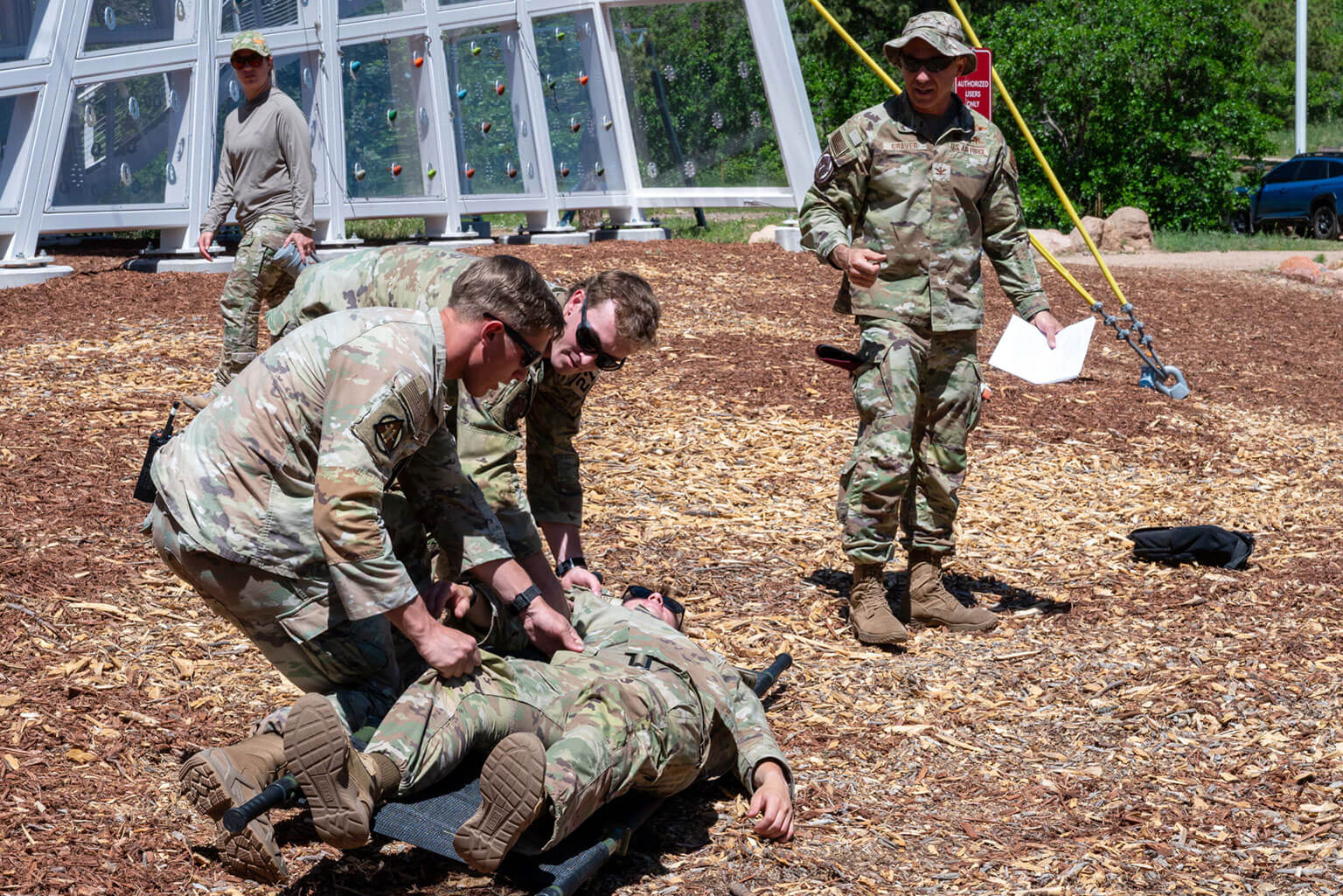 Col. John Graver (right), Headquarters Air Force, Special Warfare Division, oversees cadre demonstrating a litter carry during a Special Warfare Orientation Course (SWOC) Tactical Combat Casualty Care session at the U.S. Air Force Academy, Colo., June 11, 2026. SWOC is a two-week course that gives Academy and ROTC cadets firsthand exposure to Air Force Special Warfare career fields. (U.S. Air Force photo by Tech. Sgt. Zach Vaughn)