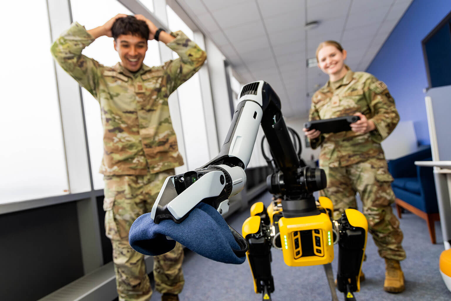 Cadet 1st Class John Alves, left, and Cadet 1st Class Jessica Cianfaglione, right, operate a robotic dog using a remote controller at the U.S. Air Force Academy, Colo., Oct. 14, 2026. The research gives cadets hands-on experience working with robotic systems and exploring their applications. (U.S. Air Force photo by Trevor Cokley)