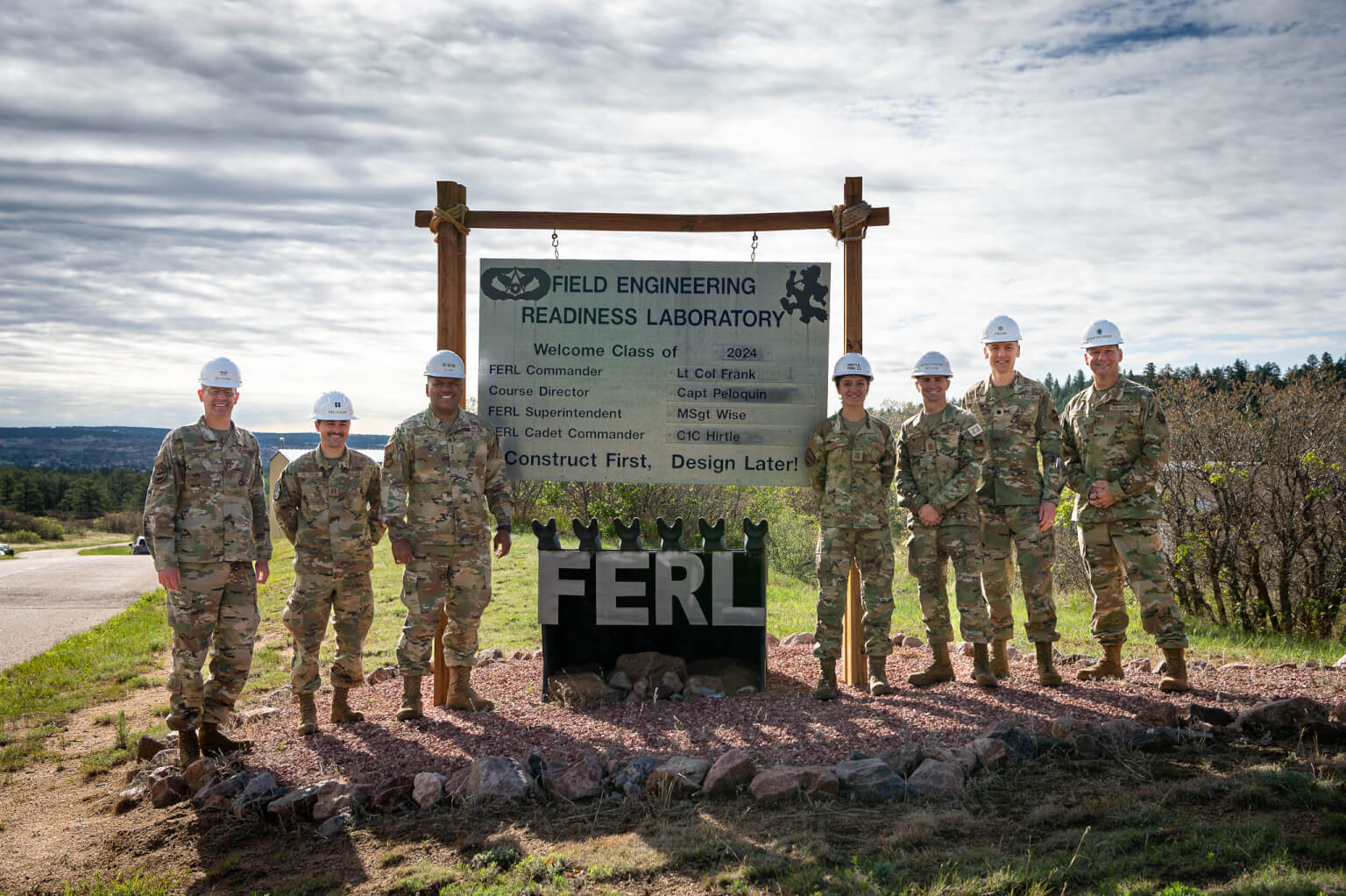 engineers in front of Field Engineering Readiness Laboratory sign