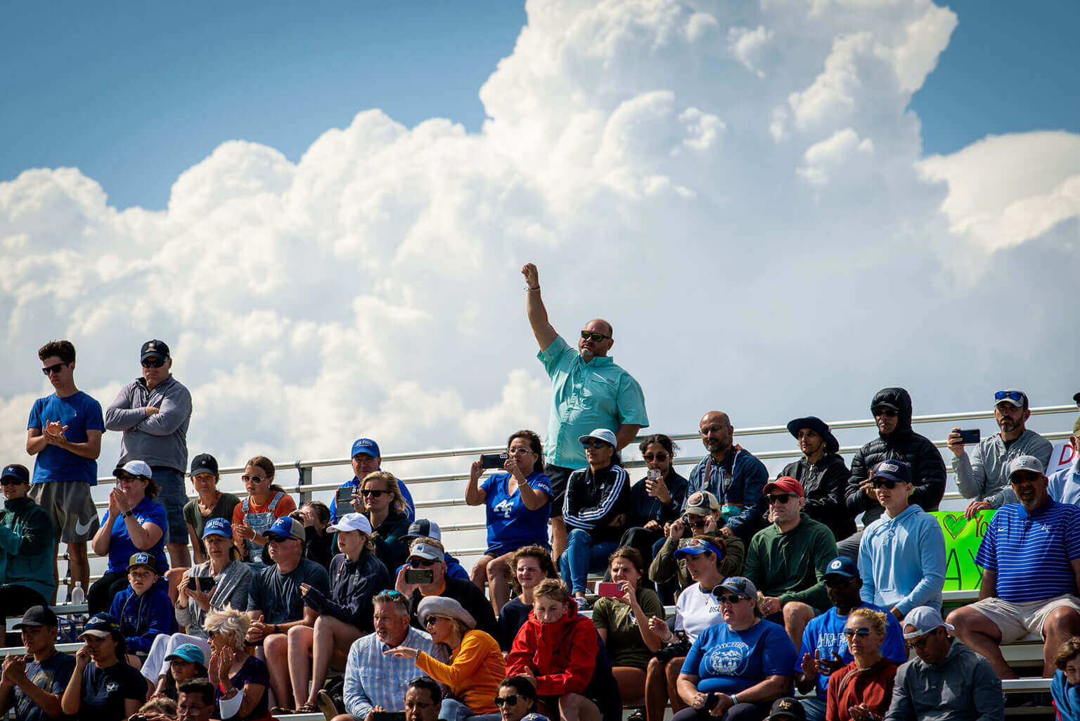 A parent raises his hand in the stands at Stillman Field during the Swearing-In Ceremony. A parent raises his hand in the stands at Stillman Field during the Swearing-In Ceremony.