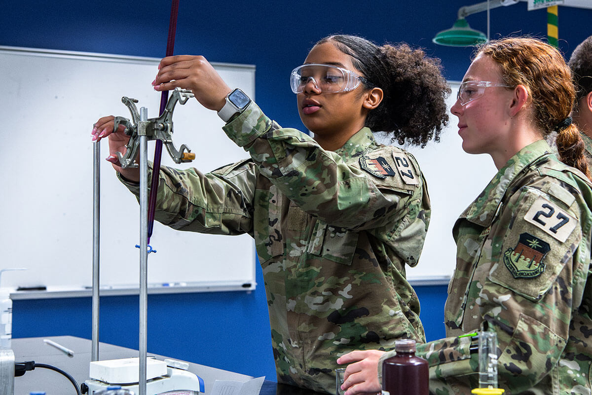 Cadets setting up an experiment using stand clamps.