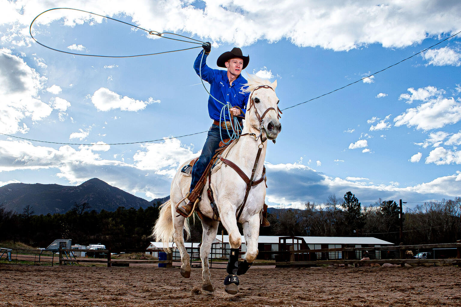 Cadet 1st Class Robert Ball lassos a roping dummy on his horse, Ferg.