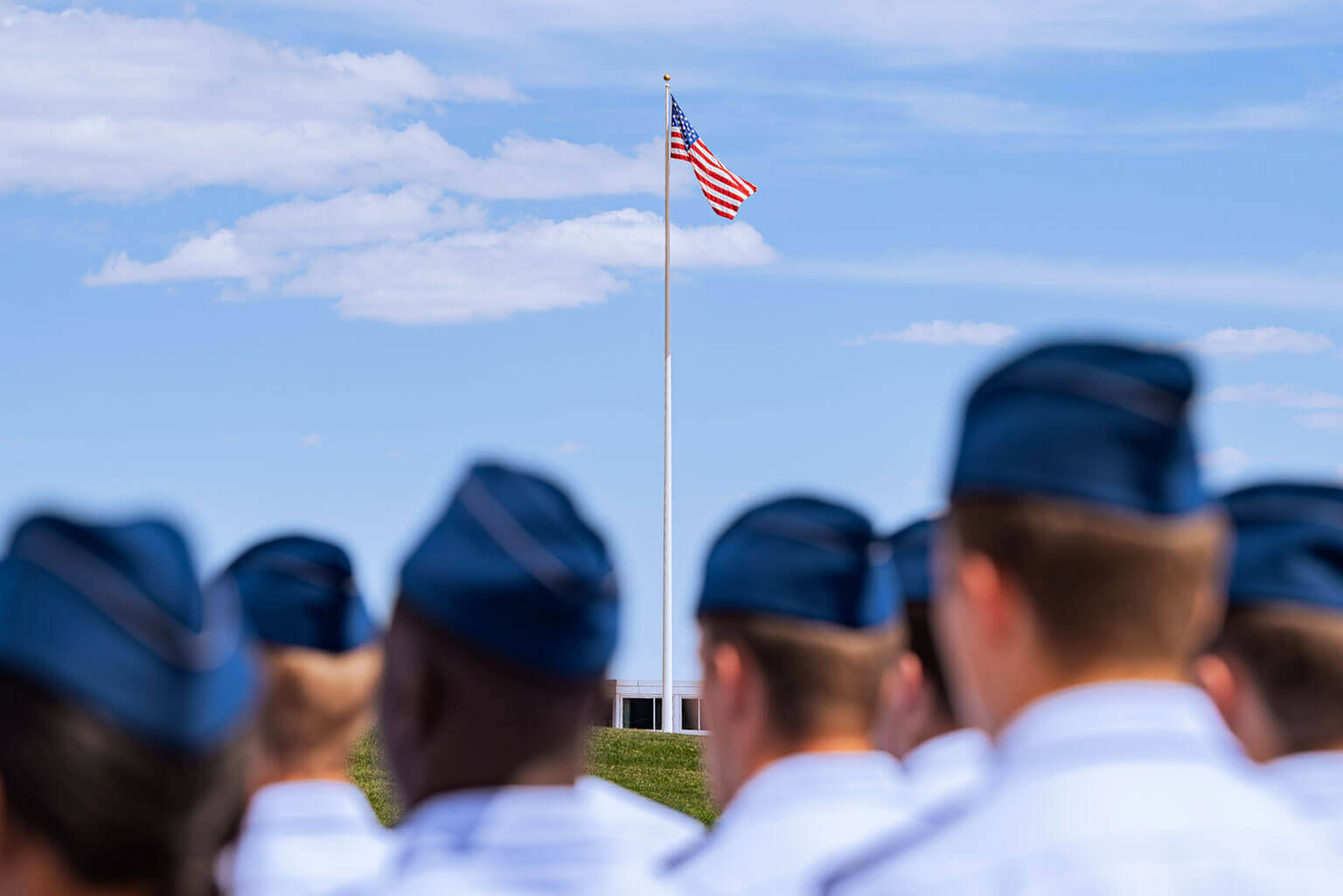 Cadets in formation on the Terrazzo with the United States flag in the background. Cadets in formation on the Terrazzo with the United States flag in the background.