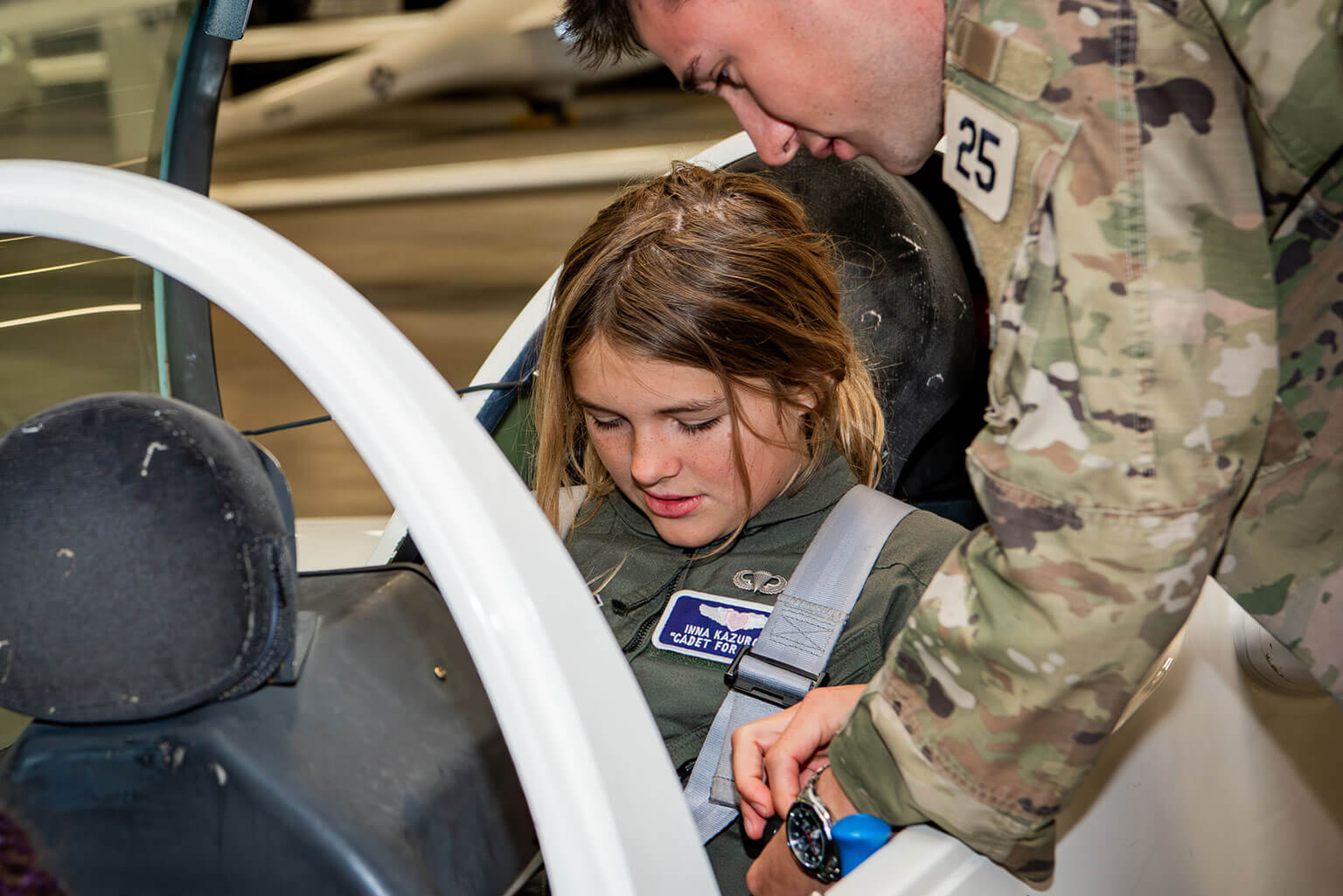Then-Cadet 1st Class Mark Carnes, Class of 2025, helping Cadet for a Day Inna Kazurova at the Davis Airfield hangar.