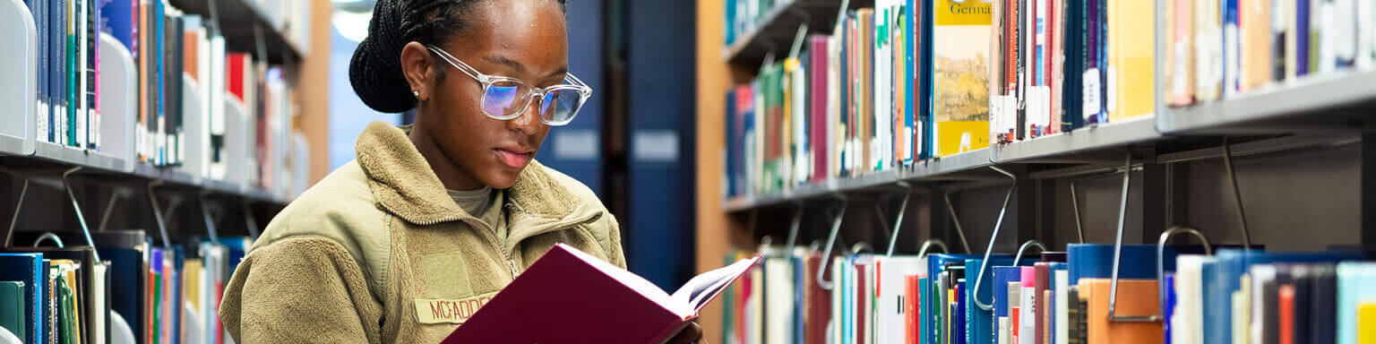 A cadet reading a book at McDermott library at the Air Force Academy.