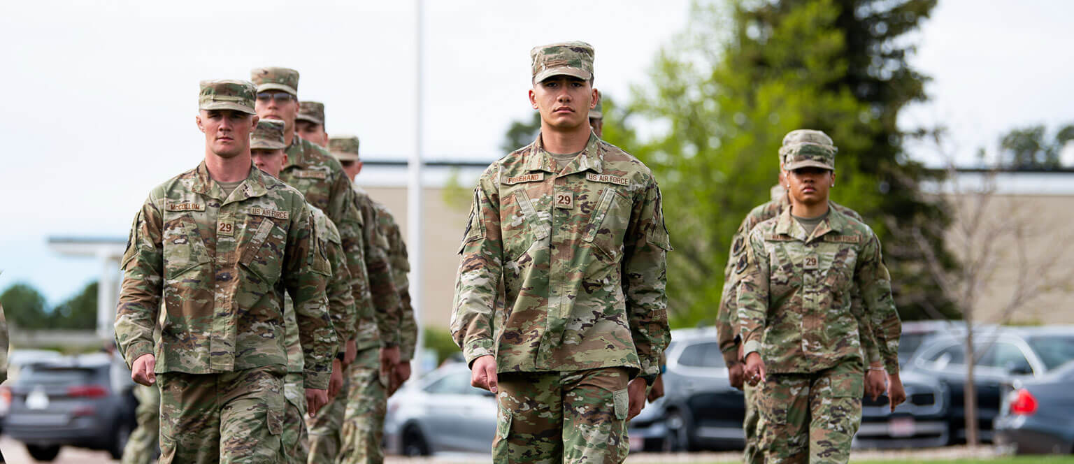 A line of cadet candidates marching in formation, showcasing discipline and teamwork among the soldiers.
