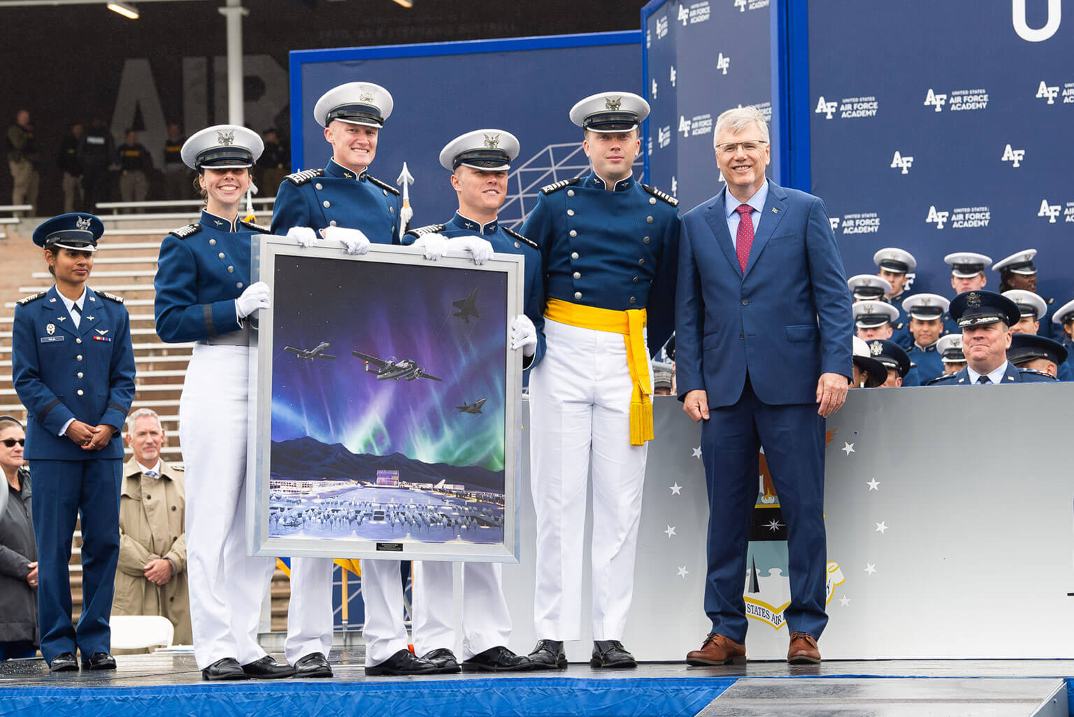 Class of 2025 cadets present a class portrait to Secretary of the Air Force Troy Meink during their graduation ceremony at Falcon Stadium.