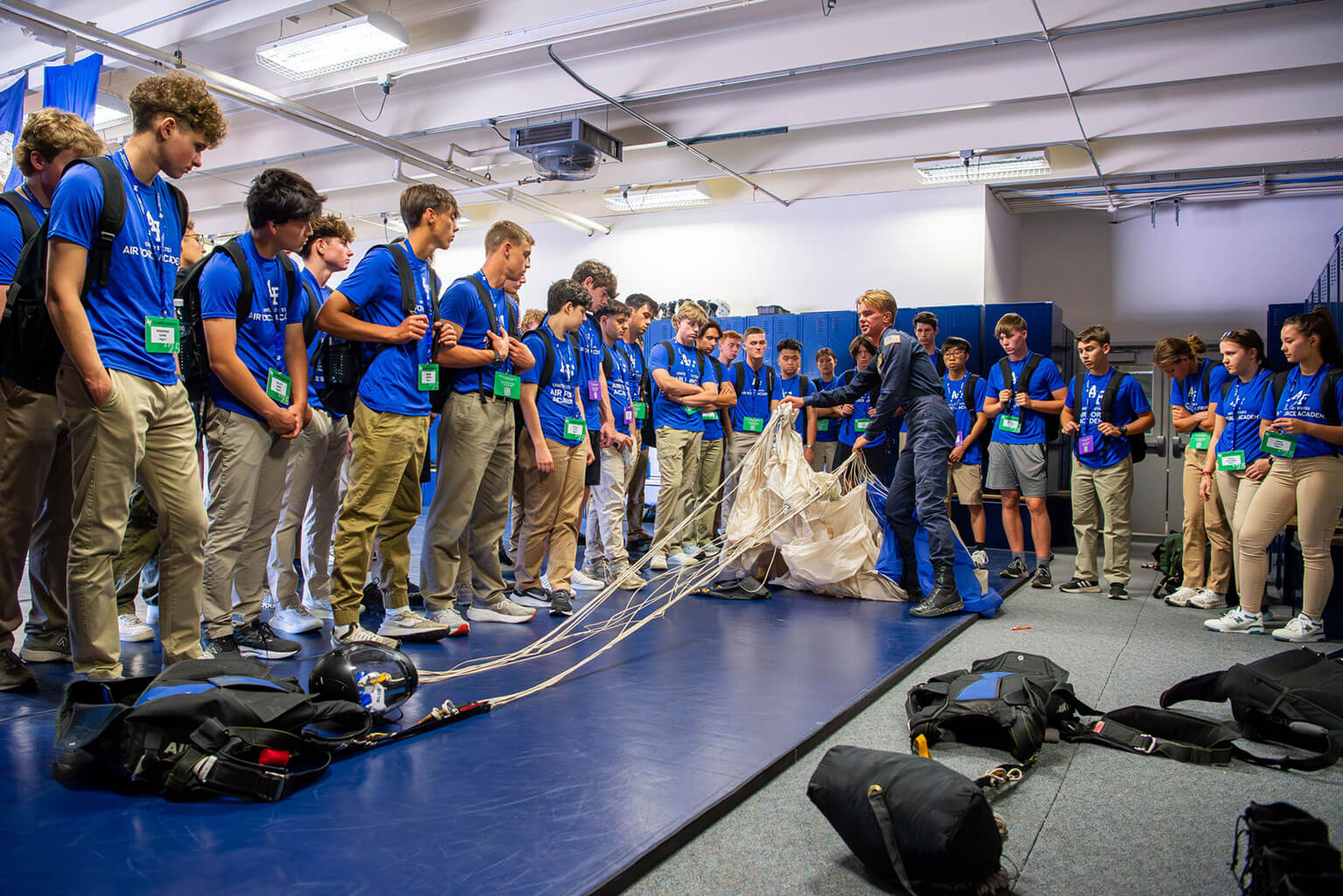 A group of rising high school seniors attending Summer Seminar watch a parachute folding demonstration at Davis Airfield, U.S. Air Force Academy, Colo., June 11, 2025. The program offers students a firsthand look at the academic, military and athletic opportunities available at the Academy. (U.S. Air Force photo by Dylan Smith)