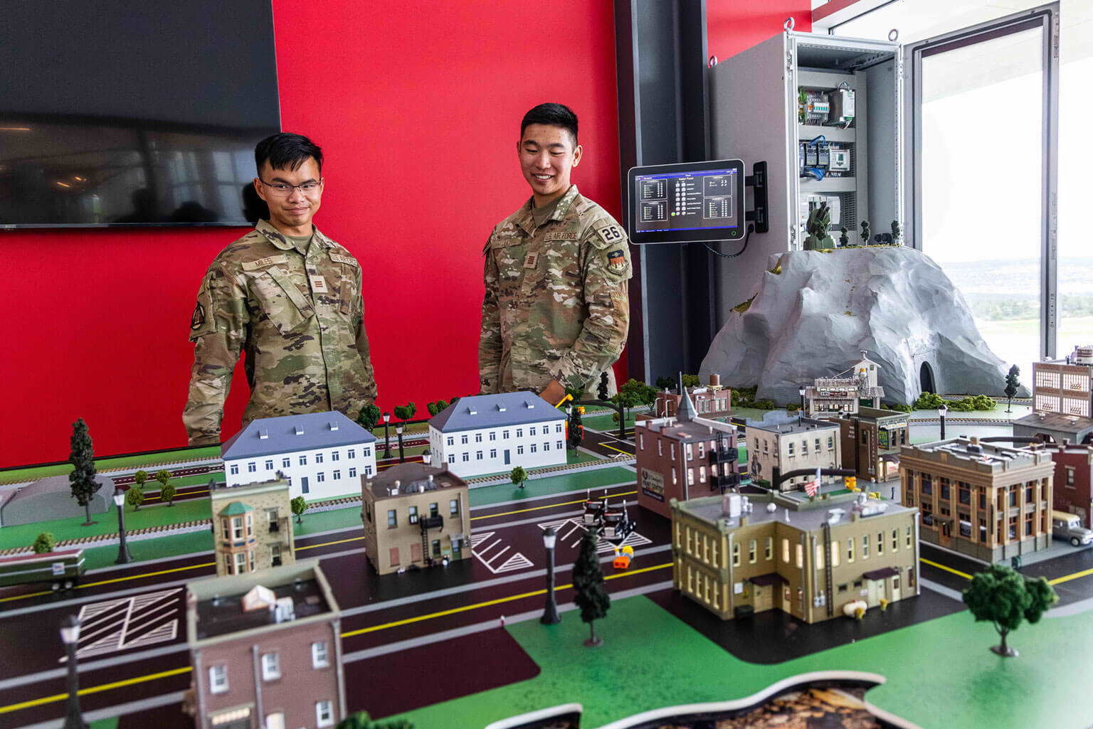Cadet 1st Class Ian Miles and Cadet 1st Class Jaden Liu use the Cyber City diorama at the Madera Cyber Innovation Center to learn how cyber-attacks can affect critical infrastructure, U.S. Air Force Academy, Colo., Aug. 7, 2025. This hands-on experience helps develop a cyber mindset that extends beyond network defense to include the ethical and operational complexities when a city suffers a cyberattack. (U.S. Air Force photo by Trevor Cokley)