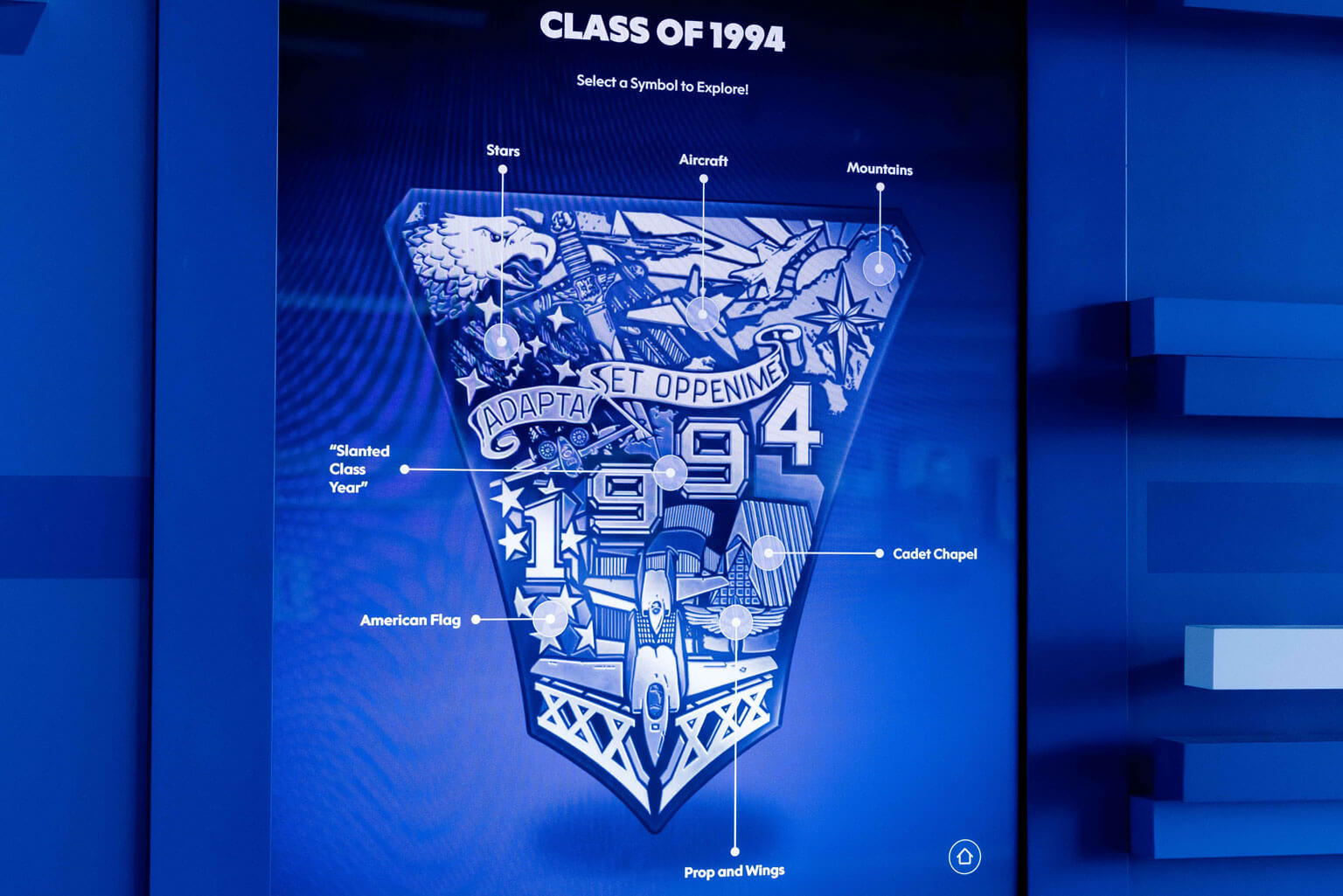 A blue wall features a blue screen showcasing the U.S. Air Force Academy 1994 class crest in blue and white.