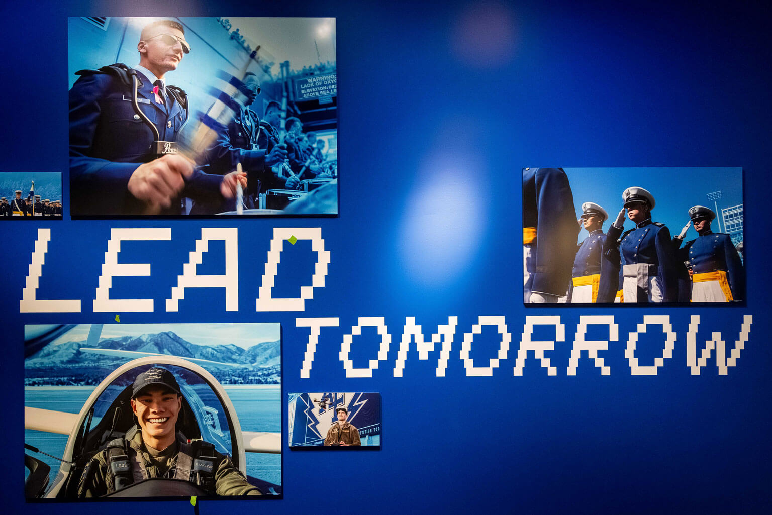 A blue wall displaying framed photographs of individuals in military uniforms.