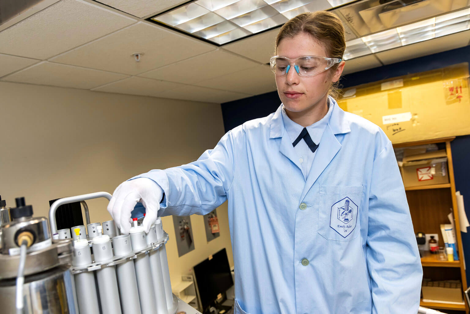 Cadet 1st Class Lauren Mirande examines volcanic rock in the Geospatial Science Laboratory, at the U.S. Air Force Academy, Colo., March 19, 2026. Mirande is learning the importance of terrain in military operations. (U.S. Air Force photo by Trevor Cokley)