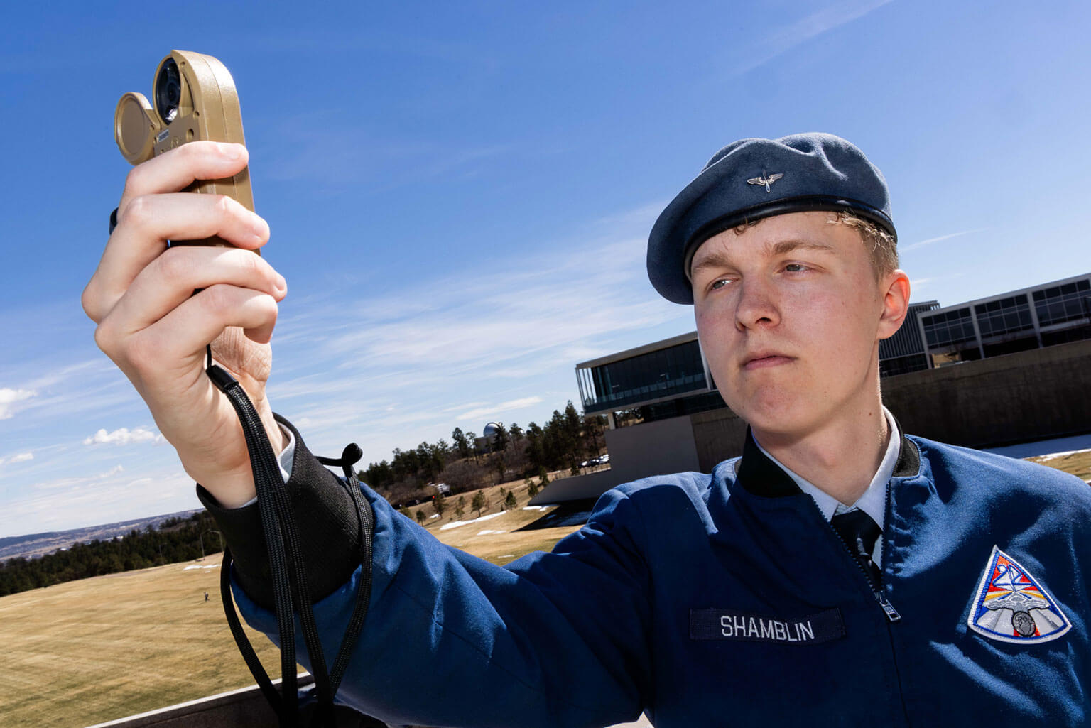 Cadet 1st Class Wyatt Shamblin uses an anemometer to check surface winds before launching a weather balloon at the U.S. Air Force Academy, Colo., March 17, 2026. Shamblin is learning the effects of weather on aircraft performance. (U.S. Air Force photo by Trevor Cokley)