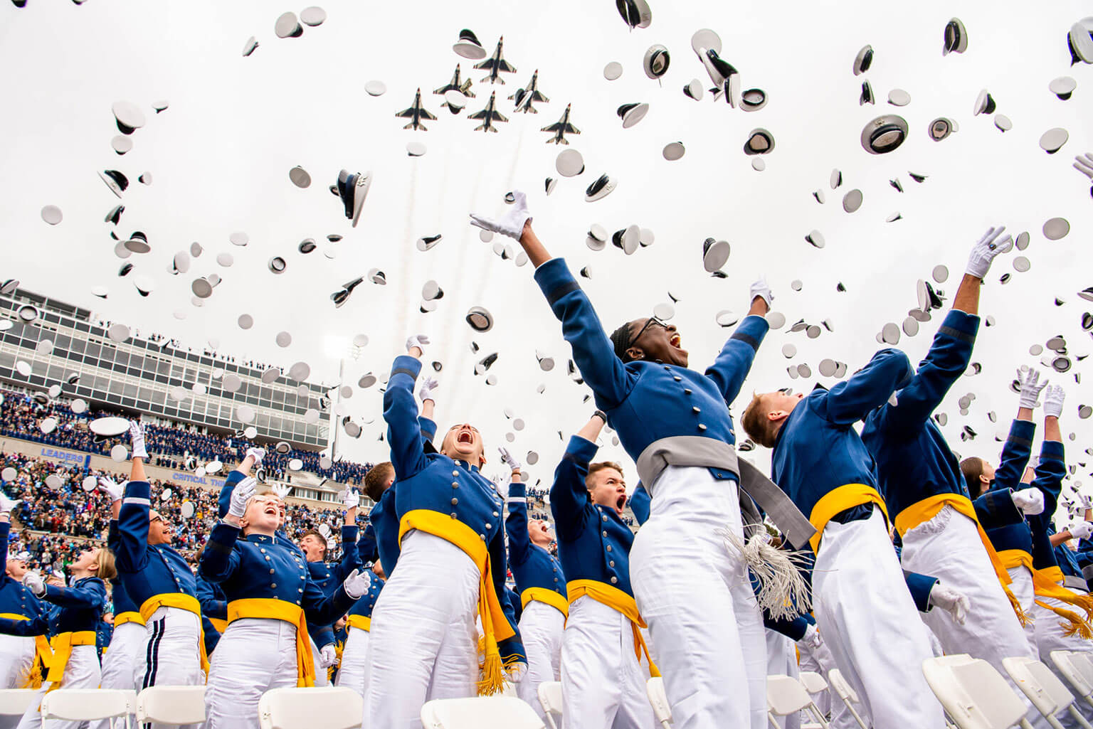 U.S. Air Force Academy graduates toss their hats skyward at Falcon Stadium after commissioning as second lieutenants during the Academy's commencement ceremony May 28, 2026. Class of 2026 stats show that 809 graduates entered the Air Force and 93 entered the Space Force, beginning their service as the nation's newest military officers. (U.S. Air Force photo by Adalyn Greene) 