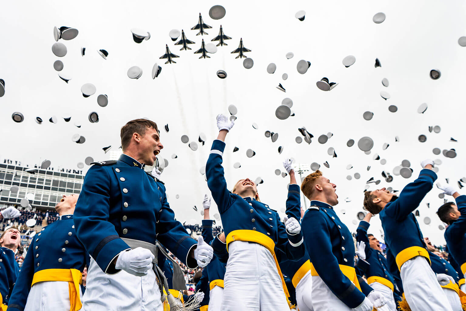 The U.S. Air Force Academy Class of 2026 graduates toss their hats skyward as the U.S. Air Force Thunderbirds roar overhead at Falcon Stadium during the 2026 graduation ceremony at the Academy, Colo., May 28, 2026. The Academy generates combat power by developing premier leaders prepared to lead and adapt in complex, contested environments. (U.S. Air Force photo by Jonathan Suni)