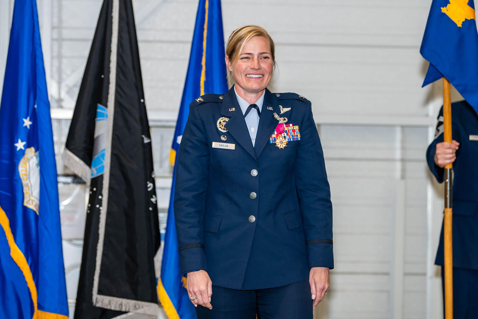 Col. Nancy E. Taylor stands in front of the unit flags during the 306th Flying Training Group change of command ceremony at Davis Airfield, U.S. Air Force Academy, Colo., June 3, 2026. The 306th Flying Training Group change of command marked the conclusion of Taylor’s tenure, during which the group returned to direct Academy oversight for the first time since 2004. (U.S. Air Force photo by Jonathan Suni)