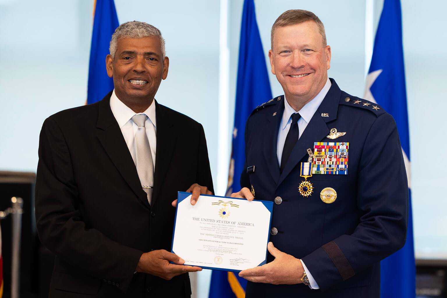 Retired U.S. Army Gen. Vincent K. Brooks, left, presents the Air Force Distinguished Service Medal to Lt. Gen. Tony D. Bauernfeind during Bauernfeind's retirement ceremony at the U.S. Air Force Academy, Colo., Aug. 7, 2026. The ceremony marked the culmination of more than three decades of service that took Bauernfeind from the cockpit of MC-130 Combat Talons to the highest levels of Air Force Special Operations Command and back to lead his alma mater.