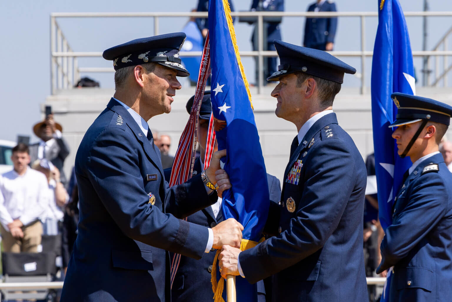 Air Force Chief of Staff Gen. Ken Wilsbach passes the U.S. Air Force Academy guidon from Lt. Gen. Tony Bauernfeind to Lt. Gen. Paul D. Moga during the U.S. Air Force Academy change of command ceremony on Stillman Field, Aug. 7, 2026. The passing of the guidon symbolizes the formal transfer of command and responsibility to the Academy's 23rd Superintendent. (U.S. Air Force photo by Trevor Cokley)