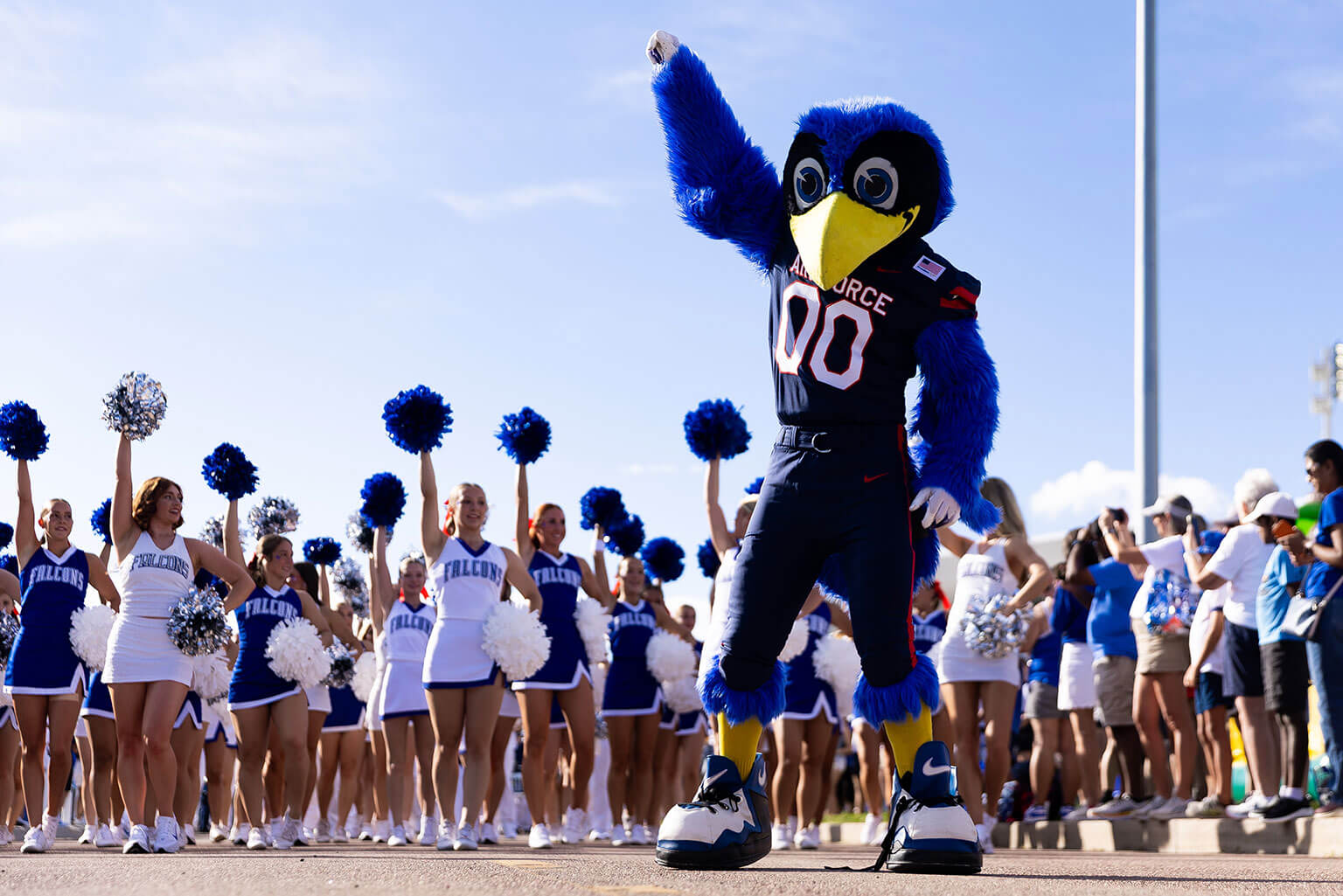 The Bird mascot stands proudly in front of U.S. Air Force Academy cheerleaders, who are cheering enthusiastically. The Bird mascot stands proudly in front of U.S. Air Force Academy cheerleaders, who are cheering enthusiastically.