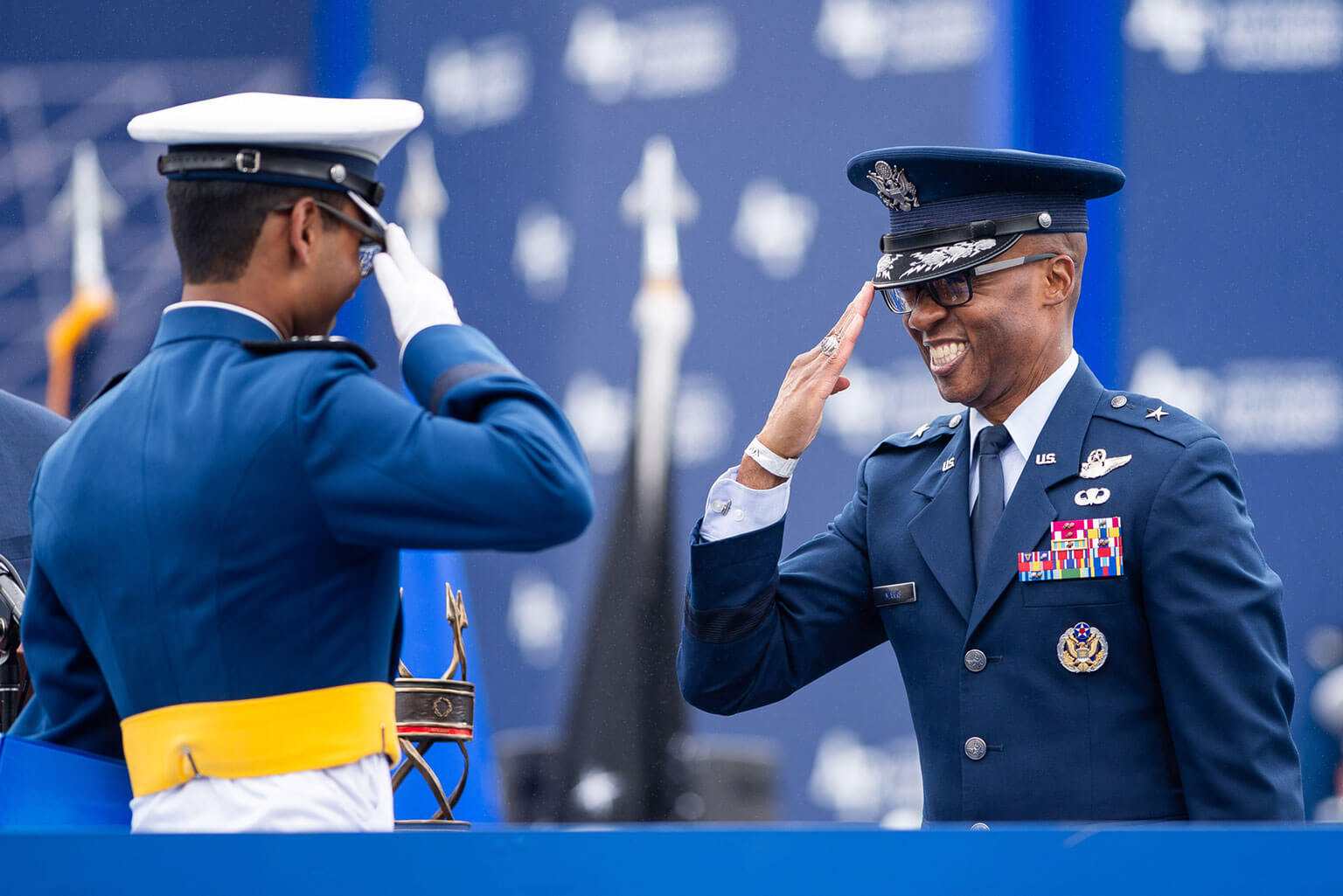 Brig. Gen. Gavin P. Marks, commandant of cadets, salutes with a member of the U.S. Air Force Academy Class of 2025 at Falcon Stadium in Colorado Springs, Colo., May 29, 2025. Nine hundred and nine cadets received commissions as second lieutenants in the Air Force or Space Force. (U.S. Air Force photo by Dylan Smith)