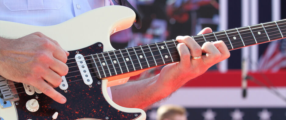 A member of the Air Force Academy Band plays an electric guitar.