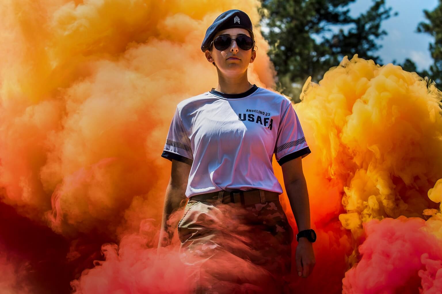 A cadet cadre walks through smoke