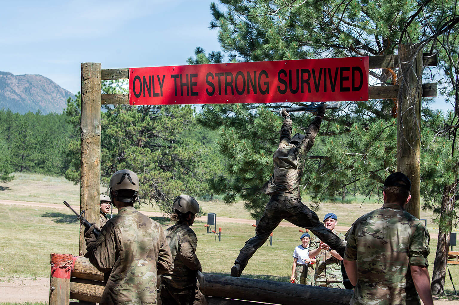 U.S. Air Force Academy cadet cadre members instruct basic cadets over the final obstacle on the assault course