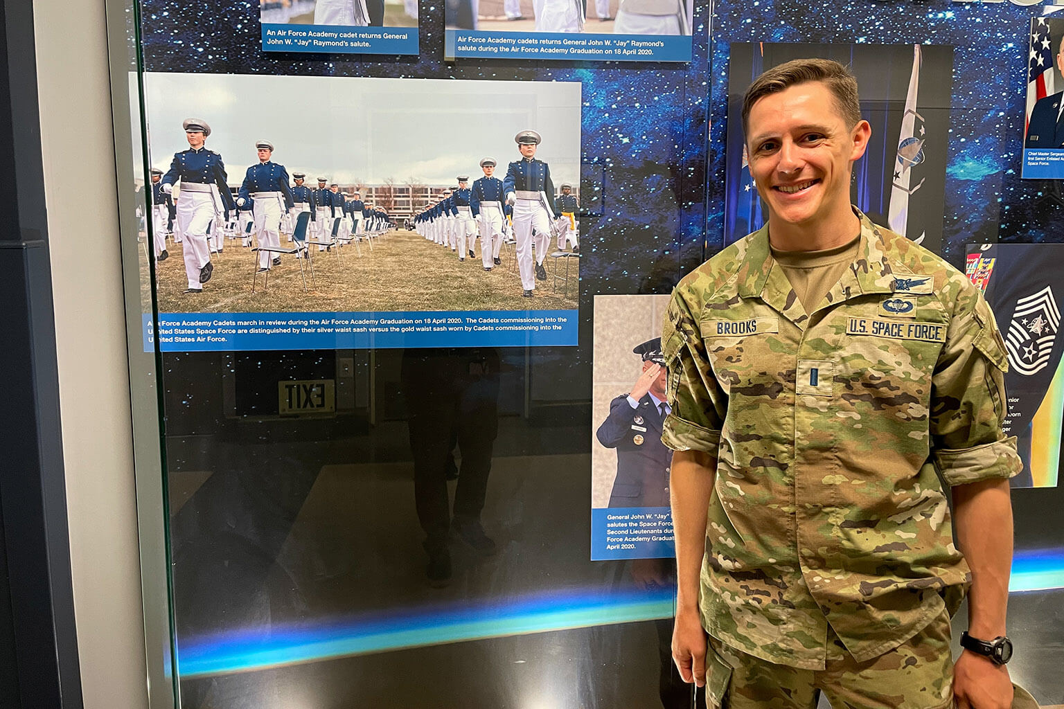 1st Lt. Aaron Brooks poses in front of an Air Force Academy display at the 