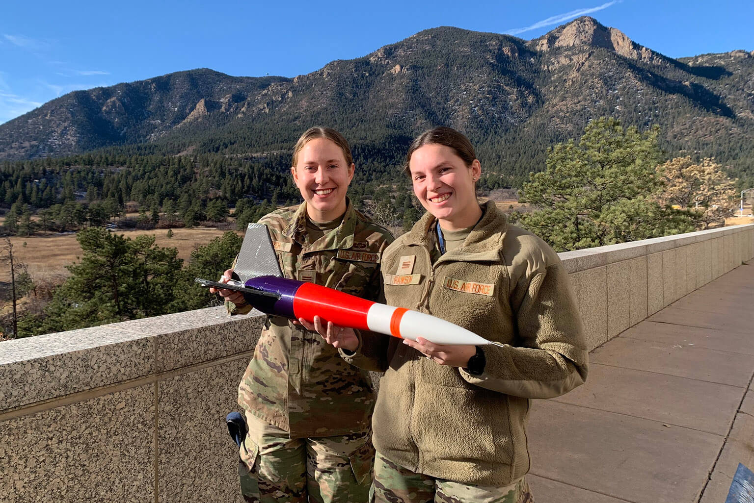 U.S. Air Force Academy Cadets 1st Class Cammie Bych and Brinley Ranson are pictured with the rocket their team built