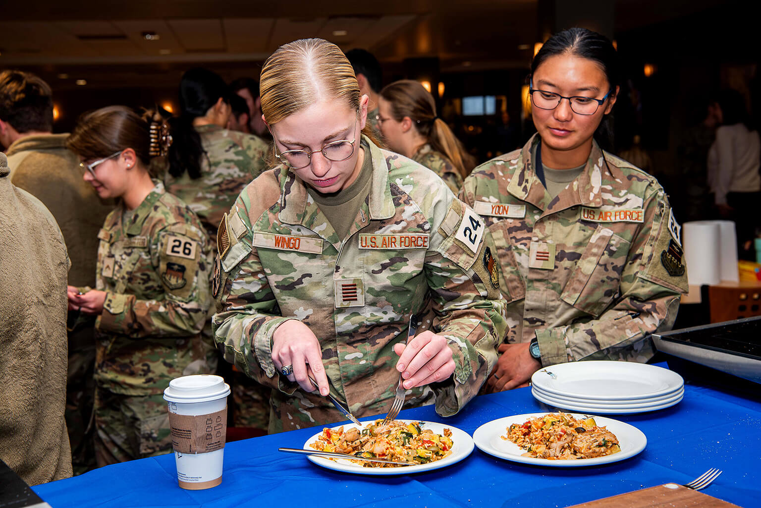 Cadet 1st Class Hannah Wingo and Cadet 1st Class Kelly Yoon try celebrity chef Robert Irvine's dish during a cooking demonstration.