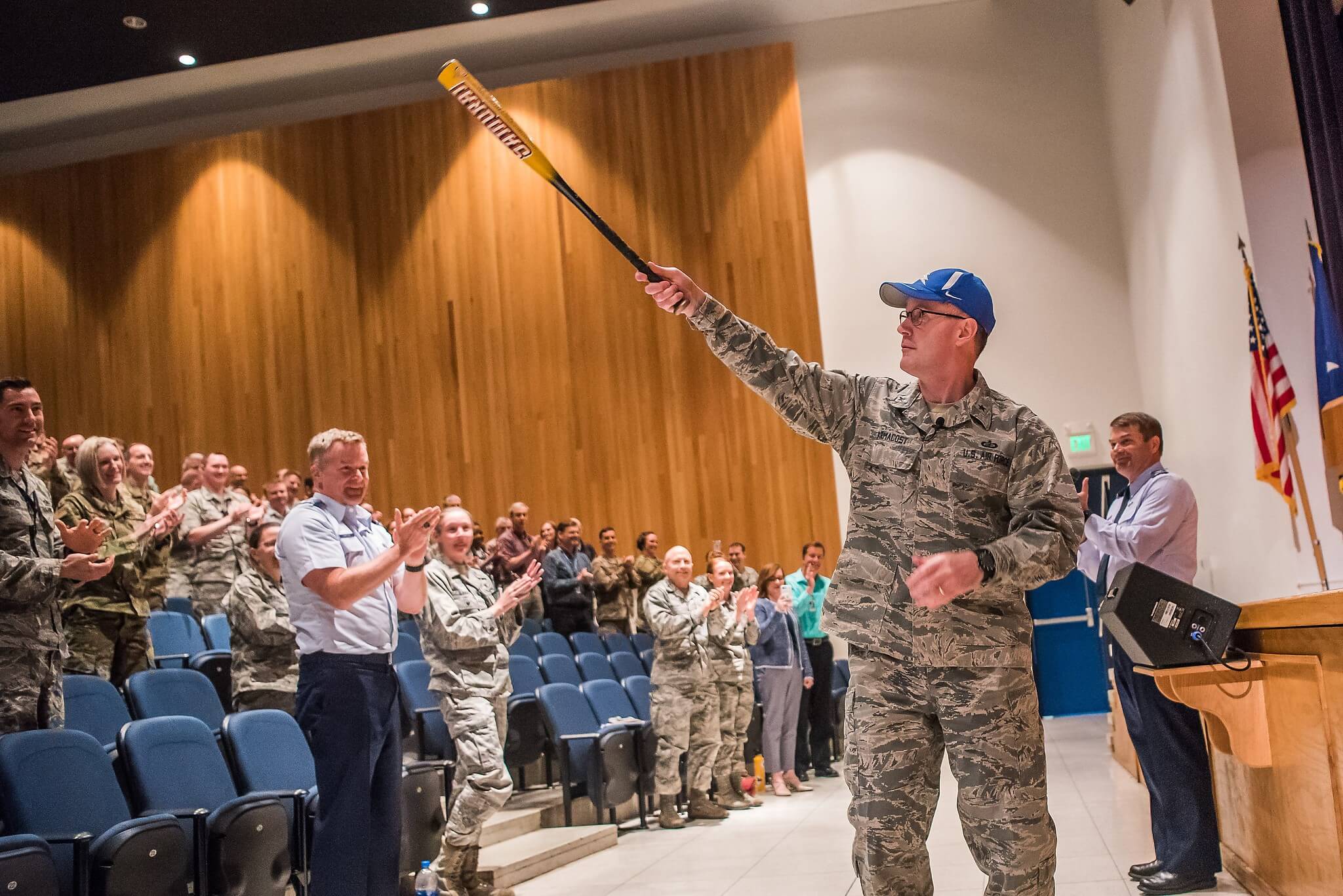 Dean Armacost on stage with baseball bat
