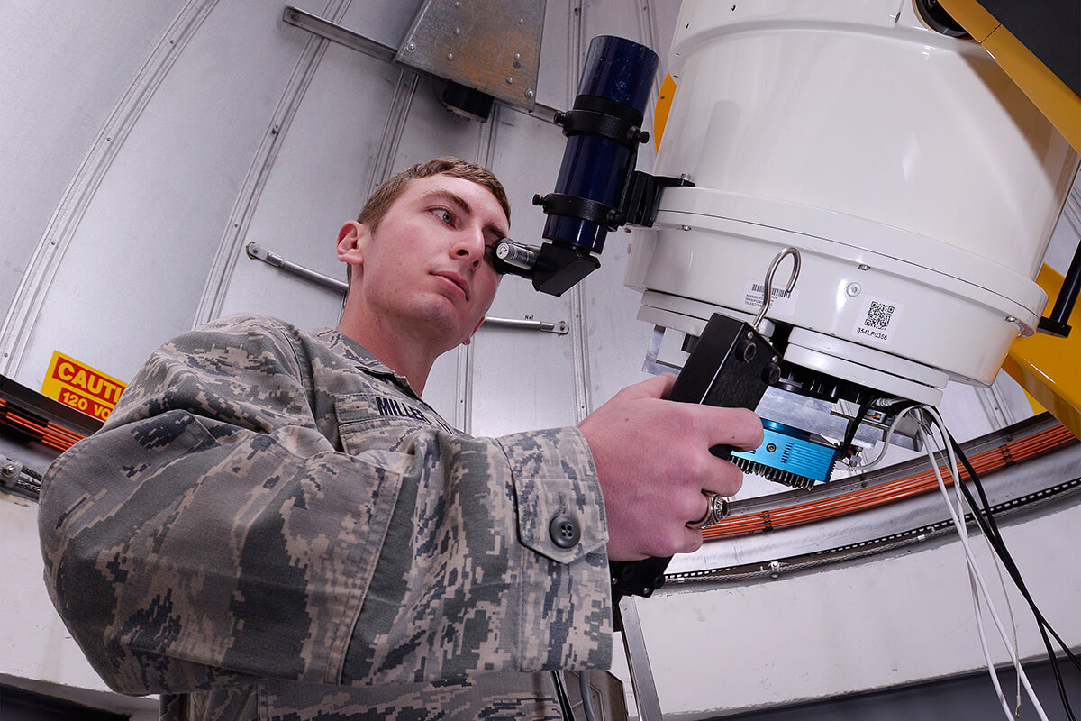 Image of cadet looking through a telescope